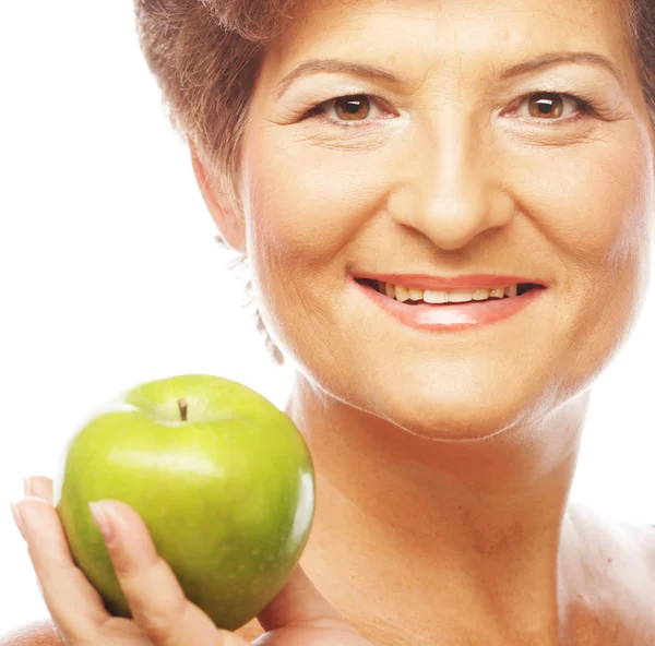 Ώριμη γυναίκα χαμογελώντας με πράσινο μήλο — Φωτογραφία Αρχείου