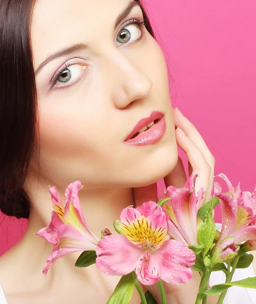 ブルネットの女性の花を持つ — ストック写真