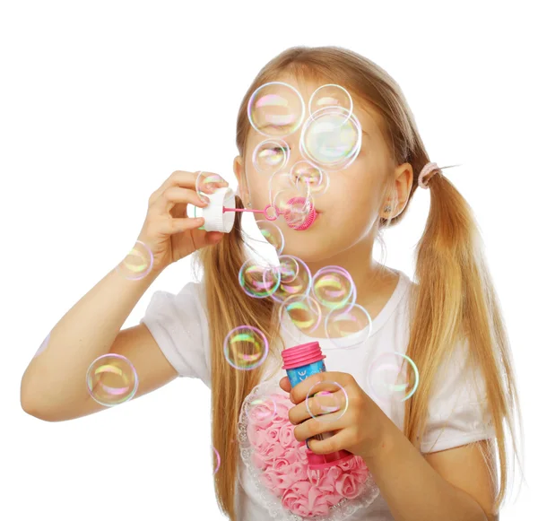 Funny lovely little girl blowing soap bubbles — Stock Photo, Image