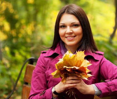 Sonbahar yaprakları olan zarif bir kadın.