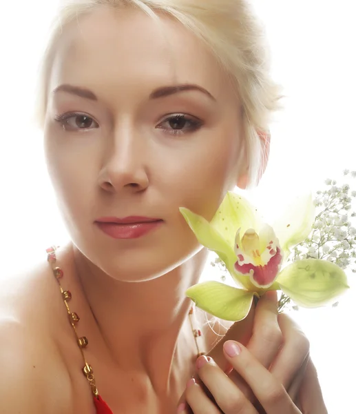 Blonde vrouw met groene orchideebloem — Stockfoto