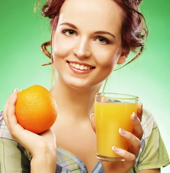 Mujer con jugo de naranja sobre fondo verde — Foto de Stock