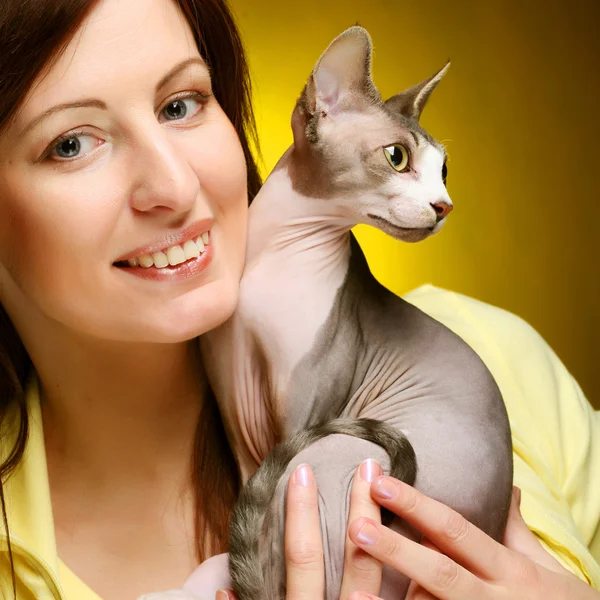 Mladá žena se zábavnou sphynx kočka — Stock fotografie