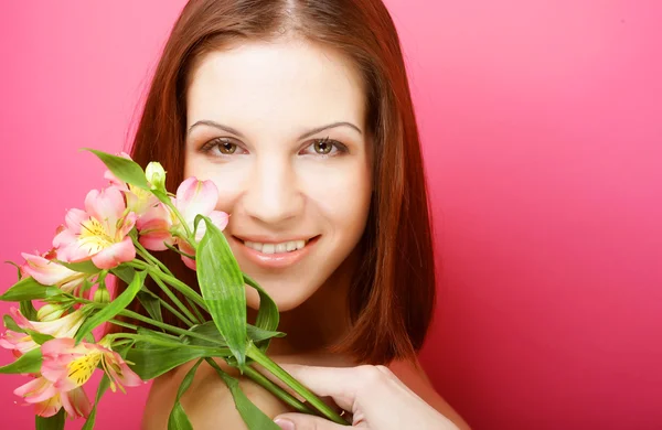 Ung vacker kvinna med rosa blommor — Stockfoto