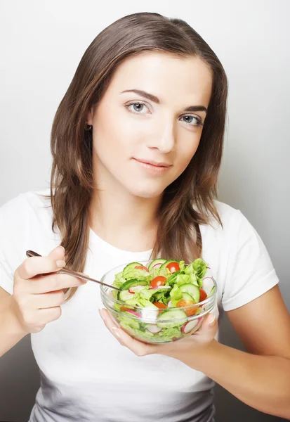 Menina com uma salada em um fundo branco — Fotografia de Stock