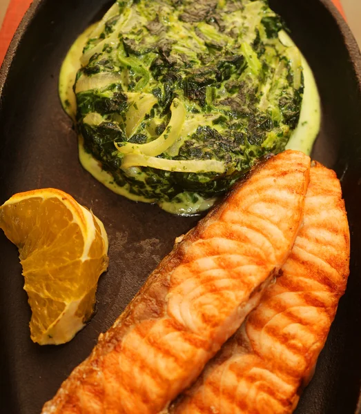 Salmon steak served with spinach — Stock Photo, Image