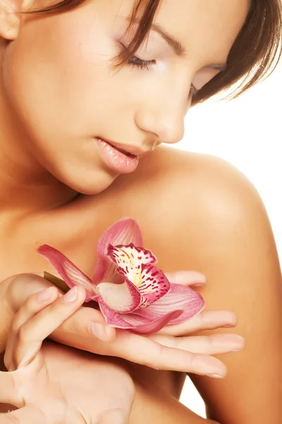 Ellerinde orkide çiçeği tutan bir kız. — Stok fotoğraf