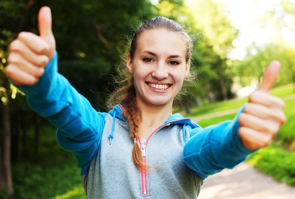 Gülümseyen kadın fitness gösterisi başparmakları — Stok fotoğraf