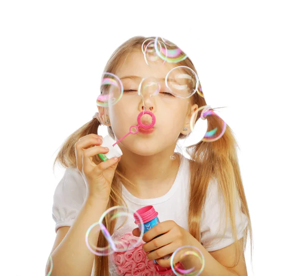 Funny lovely little girl blowing soap bubbles — Stock Photo, Image