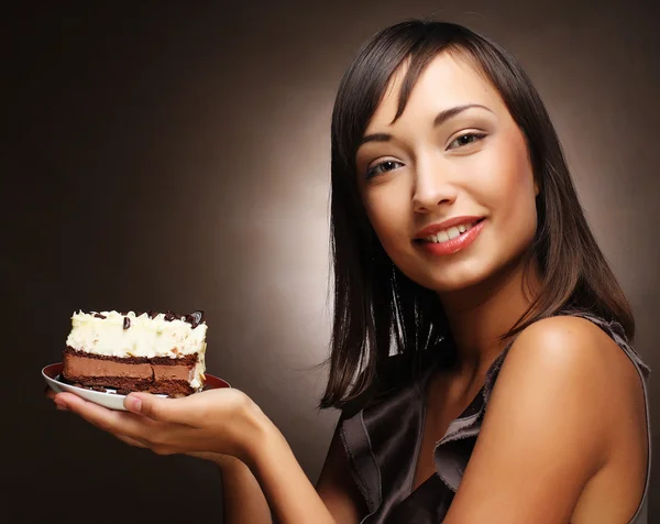 Ung kvinna äter en söt tårta — Stockfoto