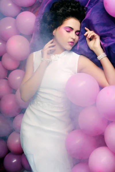 Sleeping woman lying on floor among balloons — Stock Photo, Image