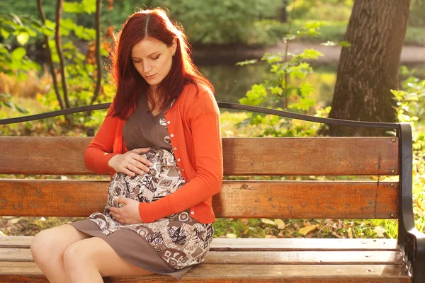 Bella donna incinta che cammina nel parco autunnale — Foto Stock