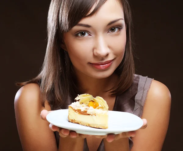 Joven mujer come un dulce pastel — Foto de Stock
