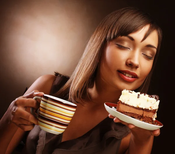 Ung kvinna med en kaka och kaffe — Stockfoto