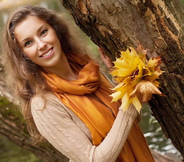 Mladá usměvavá žena v podzimním parku — Stock fotografie