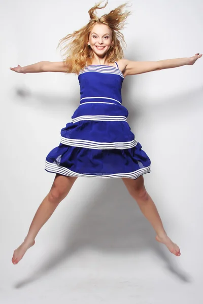 Young happy woman in blue dress jumping — Stock Photo, Image