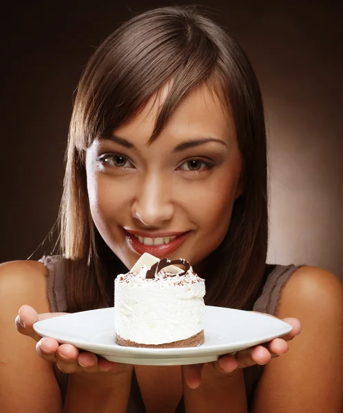 Joven mujer come un dulce pastel — Foto de Stock