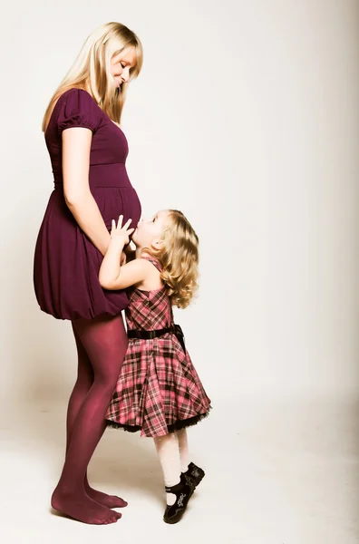 Беременная женщина с дочерью — стоковое фото