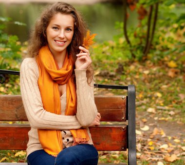 Sonbahar yaprakları olan zarif bir kadın.