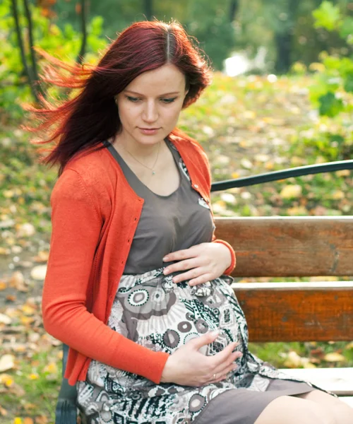 Беременная женщина, гуляющая в осеннем парке — стоковое фото