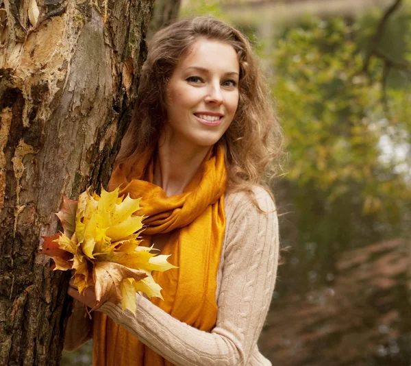 Jonge lachende vrouw in herfst park — Stockfoto
