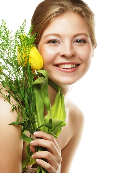 Młoda kobieta uśmiechający się z żółtych tulipanów — Zdjęcie stockowe