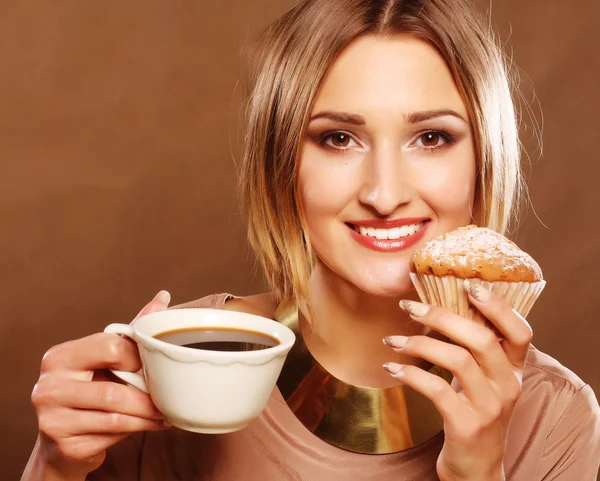 Ung kvinna med kaffe och kakor. — Stockfoto