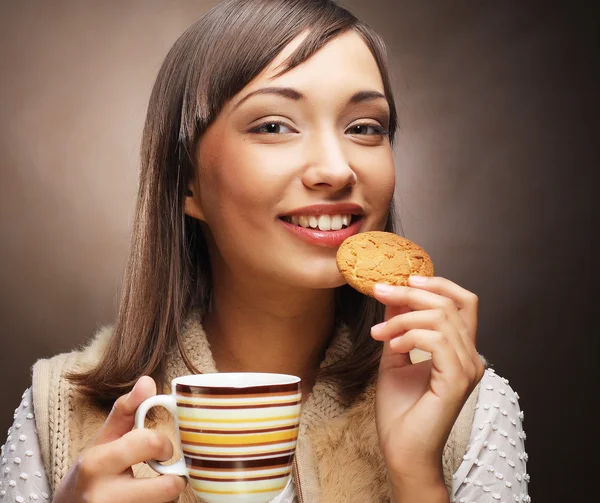 Ung kvinna med en kaka och kaffe — Stockfoto