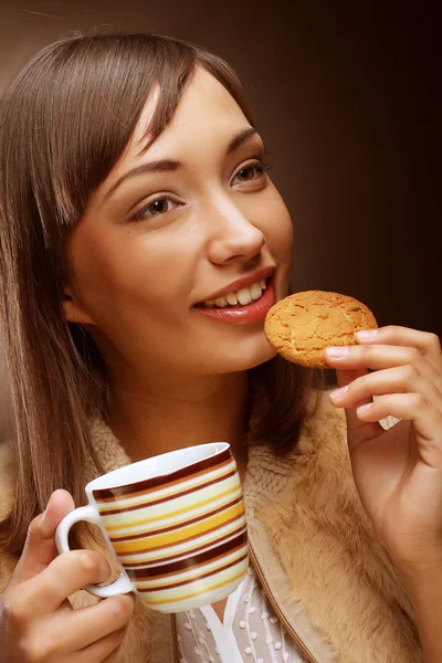Ung kvinna med en kaka och kaffe — Stockfoto