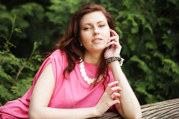 Jeune femme posant sur un arbre — Photo