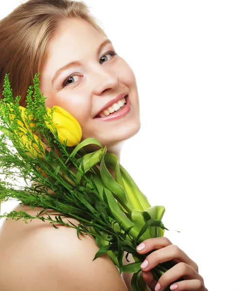 Unga leende kvinna med gula tulpaner — Stockfoto