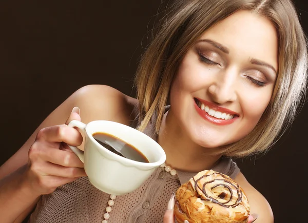 Ung kvinna med kaffe och kakor. — Stockfoto