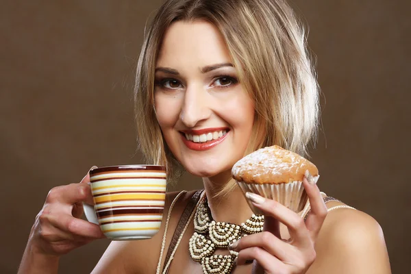 Młoda kobieta z kawą i ciasteczkami. — Zdjęcie stockowe