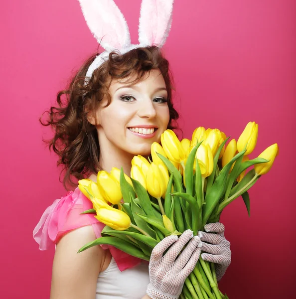 Mulher com orelhas de coelho segurando tulipas amarelas — Fotografia de Stock