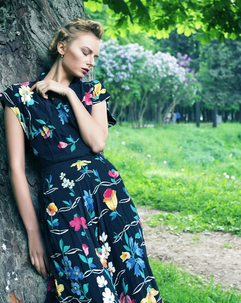 Giovane donna posa su un albero — Foto Stock