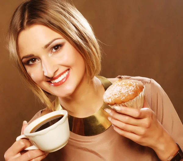 Ung kvinna med kaffe och kakor. — Stockfoto