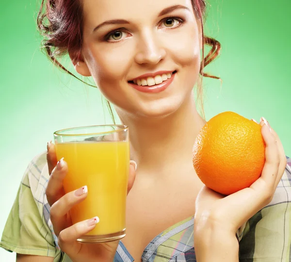 Mujer con jugo de naranja sobre fondo verde — Foto de Stock