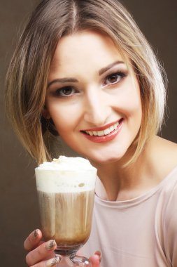 Kahve fincanı tutan genç bir kadın. 