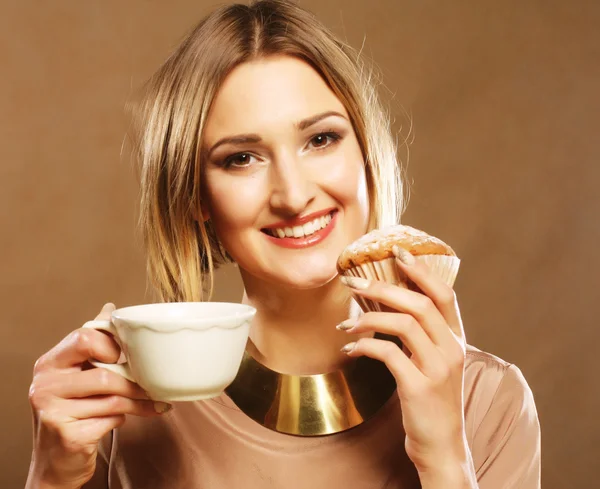 Ung kvinna med kaffe och kakor. — Stockfoto