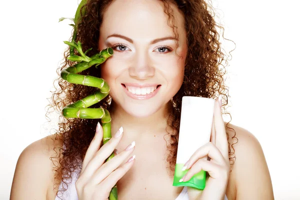 Menina spa bonita segurando frasco de creme e bambu — Fotografia de Stock