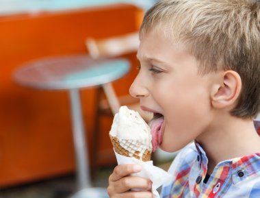 Yaz aylarında açık havada kafede bir dondurma yemek güzel çocuk. Yaz tatil kavramı.
