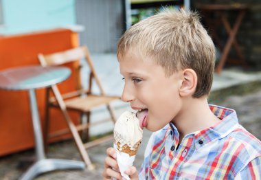 Güzel çocuk kafede yaz aylarında dondurma yeme. Yaz tatil kavramı.