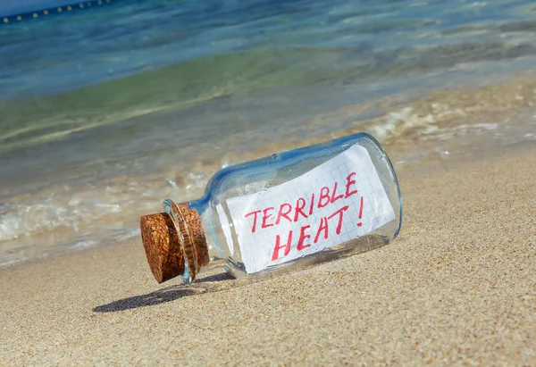 Message in a bottle "Terrible heat". Creative summer break concept. — Stock Photo, Image