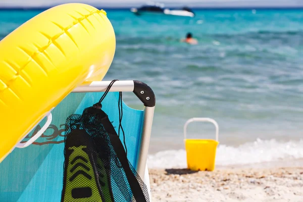 Strandstoel met opblaasbare float en duiker vinnen op strand. Zomer vakantie concept. — Stockfoto