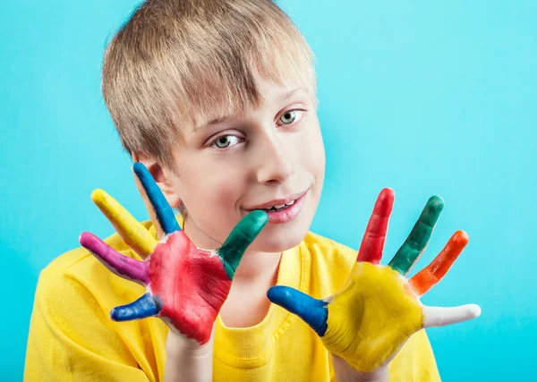 Hermoso niño blanco alegre en camiseta amarilla que muestra las manos pintadas con expresión divertida —  Fotos de Stock