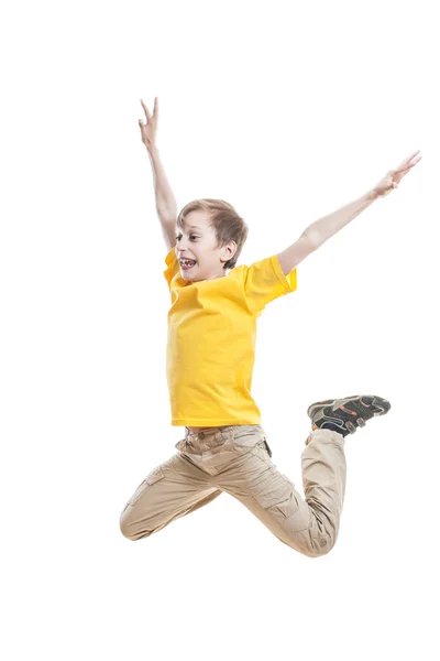 Niño divertido en colorida camiseta saltando y riendo sobre fondo blanco — Foto de Stock