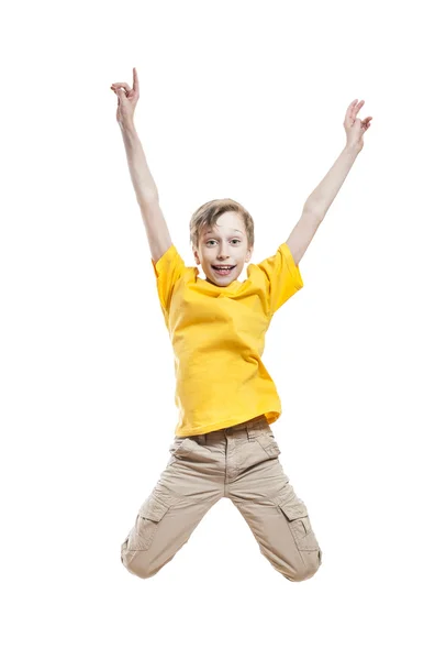 Lustiges kleines Kind hüpft und lacht und zeigt mit dem Zeigefinger über weißen Hintergrund — Stockfoto