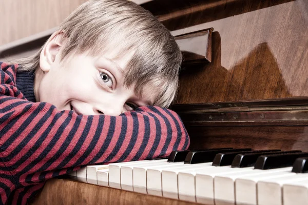 Muzyk piękne śmieszne dziecka spoczywa na klawiaturę fortepianu uśmiechający się — Zdjęcie stockowe