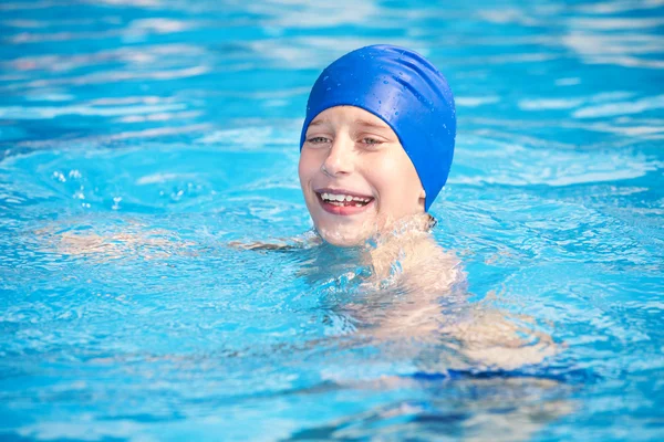 Lindo niño divertido en gorra de nadador nadando en una piscina soleada riendo —  Fotos de Stock