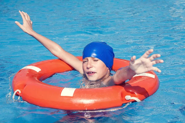 Mooie jongen gered van de verdrinkingsdood in een zwembad door een leven-bouy (help concept) — Stockfoto